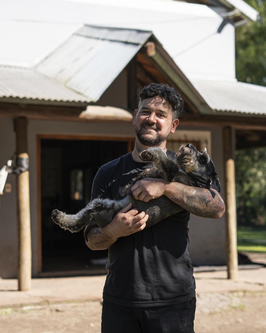 Un integrante del equipo con un cachorro schnauzer en brazos