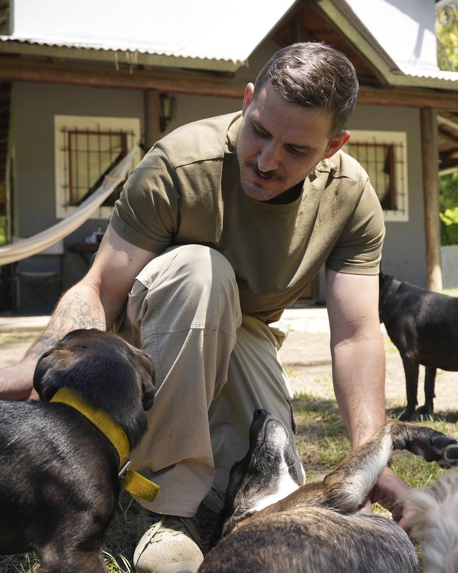 Un integrante del equipo acariciando a varios perros